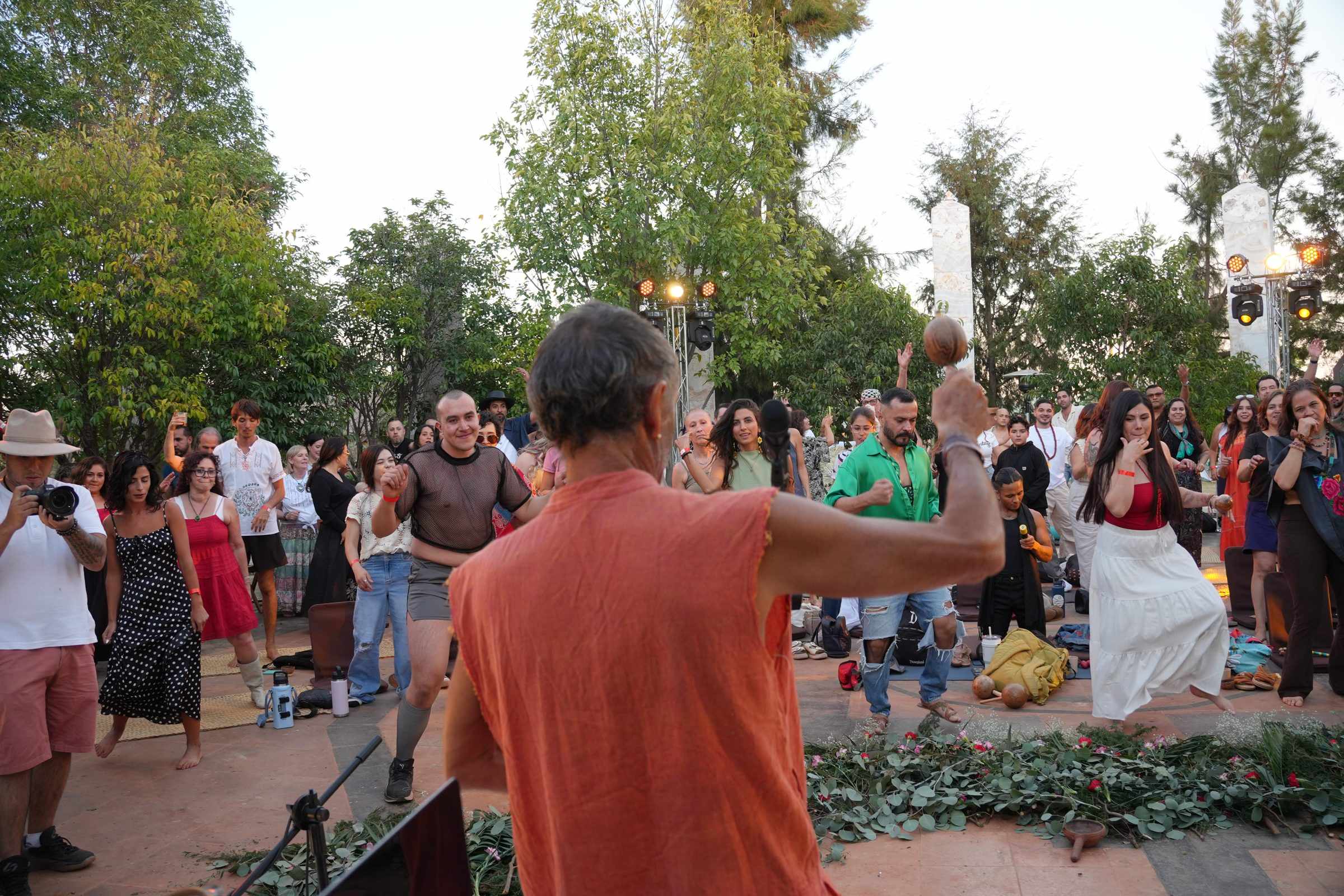 A facilitator leading a group dance between the onyx columns
