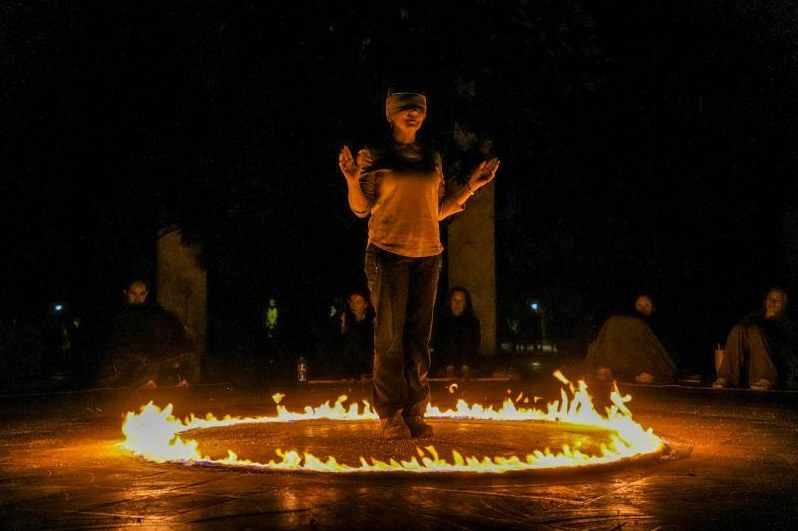 A fire circle at night with guests seated around it