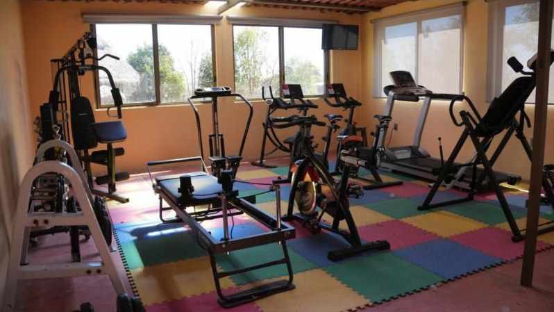 The gym with a Pilates reformer, bikes and a treadmill