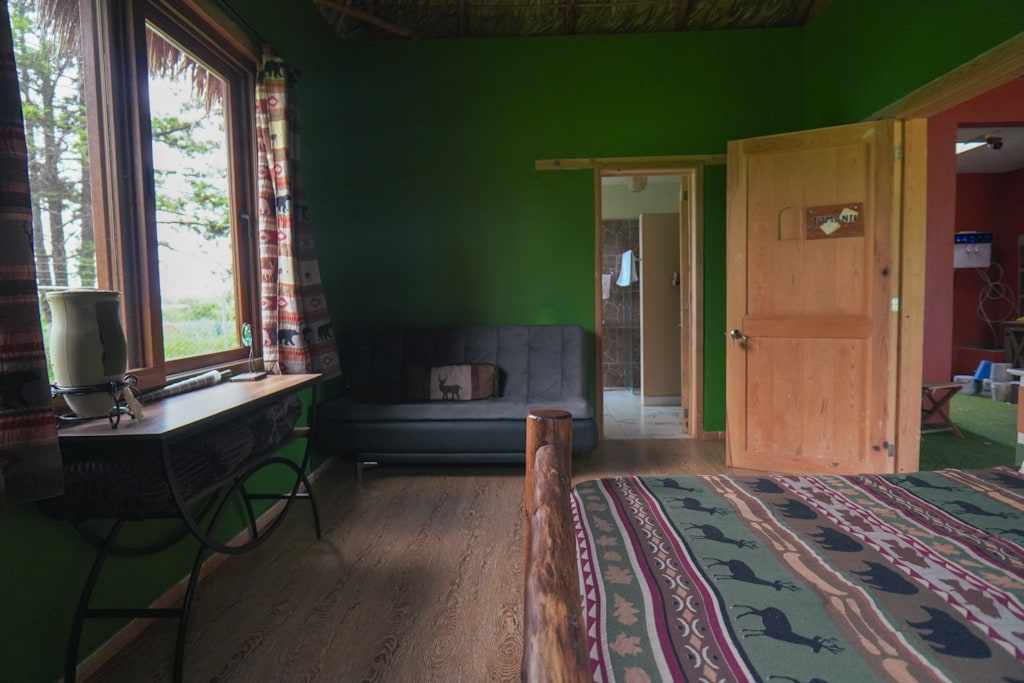 Jumanji, a green room with a palm roof and a sofa bed