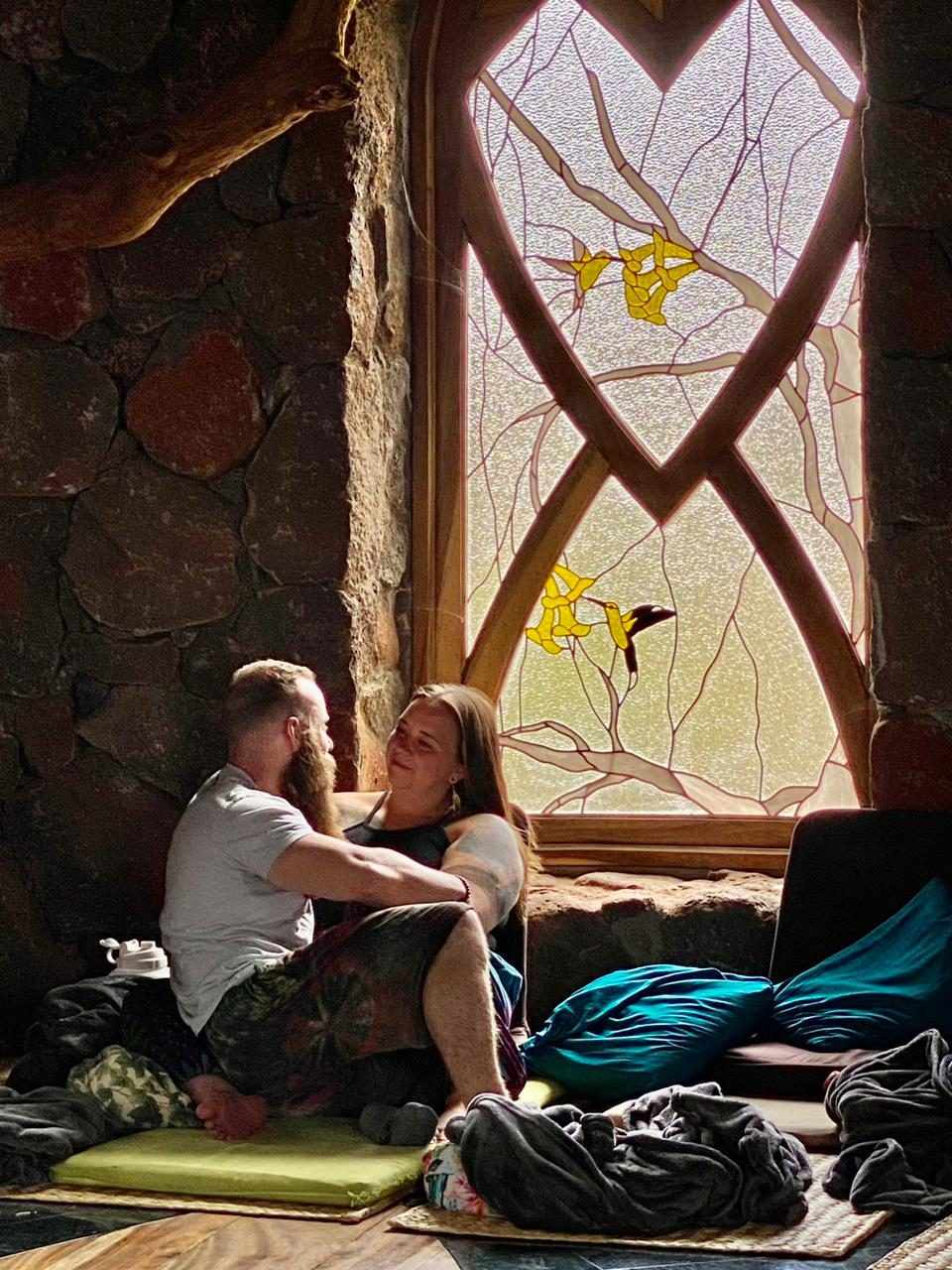 Two guests resting by the hummingbird window in the Osho Hut